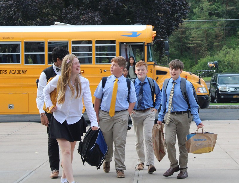 welcome back cba students image of school bus and happy students walking to school