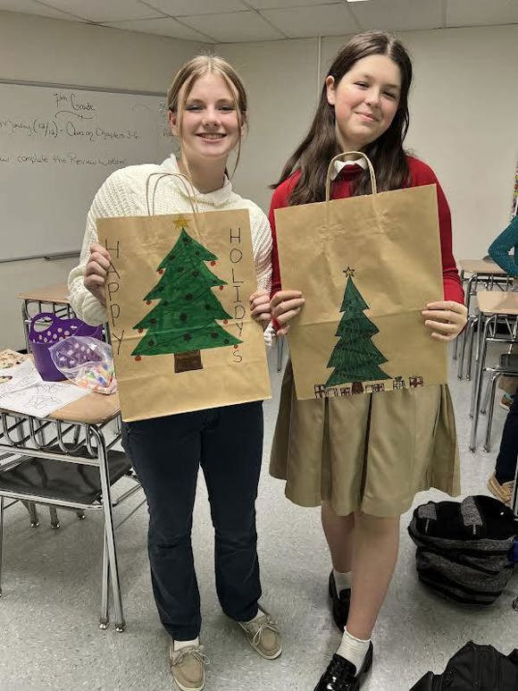 merry christmas near syracuse students holding artwork