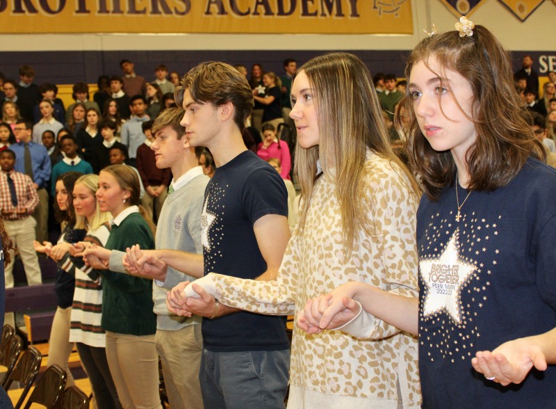 cba community celebrates the feast of the immaculate conception image of students reading at assembly near syracuse ny