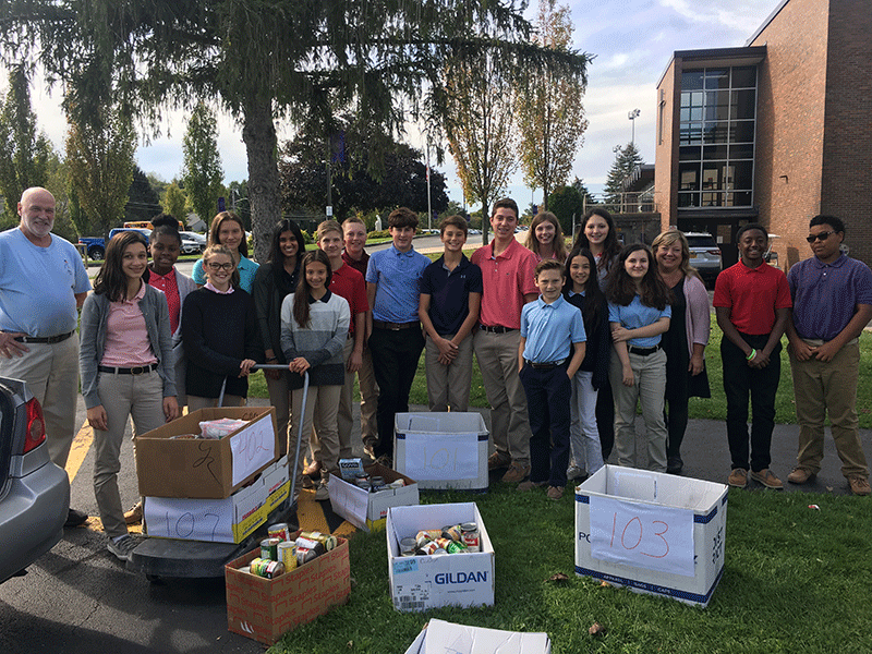 Seventh graders help to load Friar Greg’s (Assumption Church Food Pantry) car with the donated food