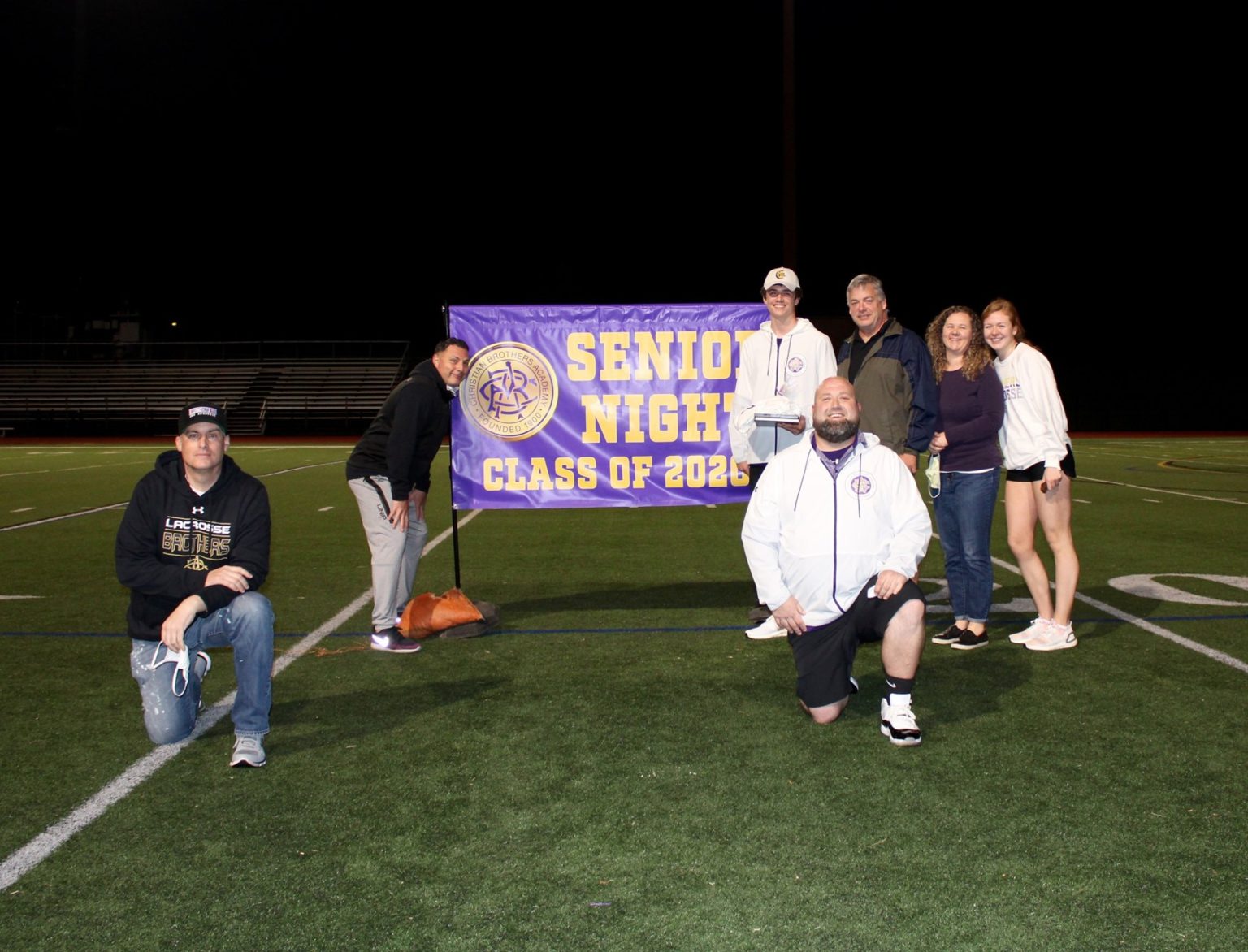 Colin Kelly and family with assistant lacrosse coaches (front) Mike Holdridge and Shaun Kazimer and head coach Ric Beardsley.